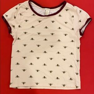 This is a light pink tee shirt with bees on it.